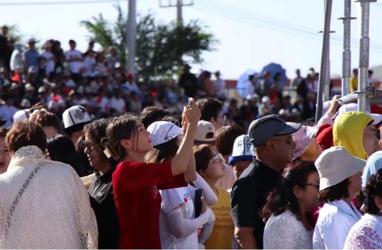 现场观众拿起手机记录精彩瞬间。人民网 李龙摄