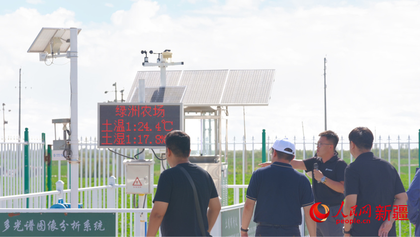 在库尔勒绿洲农场，调研组一行查看农田传感设备，并详细了解该企业通过线上智慧平台+线下运营体系所取得的成效。人民网 李欣洋摄