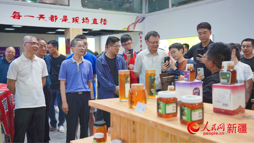 在疆域阿力木直播基地，调研组一行详细了解当地电商产业发展。人民网 李欣洋摄