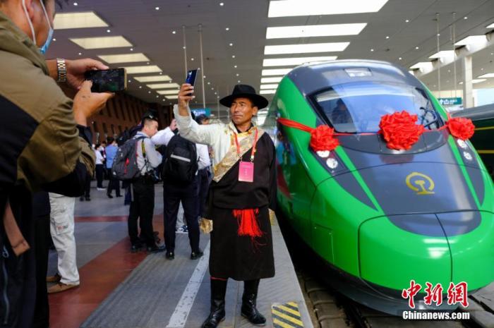 2021年6月25日，川藏铁路拉林段(拉林铁路)正式开通运营，复兴号高原内电双源动车组同步投入运营。拉林铁路全长48公里，设计时速160公里。这是西藏首条电气化铁路，也是复兴号动车组首次开进西藏。图为当日，民众在拉萨火车站复兴号车头前拍照留念。 a  href='/'中新社/a记者 江飞波 摄