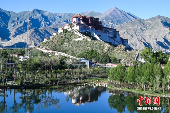 8月5日，随着西藏自治区成立60周年大庆临近，拉萨街头处处洋溢着喜庆氛围。市区主干道的路灯杆上，崭新的国旗与彩旗有序悬挂，鲜艳夺目。人行天桥完成升级改造，装饰板上国旗、石榴籽、牡丹花、浪潮、山川、连心结、雪山与哈达等元素相互交融，别具特色。工作人员正紧锣密鼓地布置花坛，五彩花卉将为城市增添斑斓色彩。此外，各大广场、公园也在装点，准备迎接八方来客。拉萨正以最美姿态，迎接这一重要时刻。图为从团结公园遥望布达拉宫。a  href='/'中新社/a记者 贡嘎来松 摄