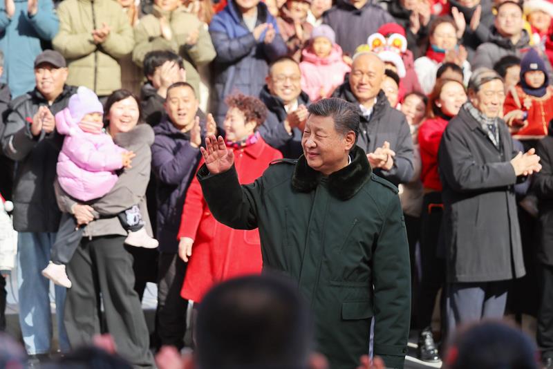 △2026年2月10日，习近平总书记在北京东城区隆福寺街区考察时，向现场群众挥手致意。
